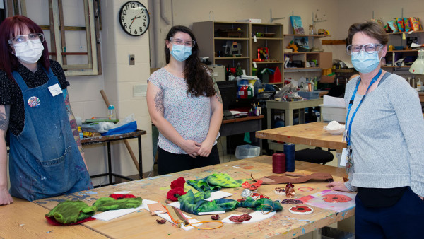 Art instructors Kim Smith, Rachel Woolmore-Goodwin and Beverly McNaughton standing at a table in the arts studio